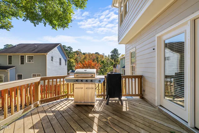 a view of a patio with table and chairs with wooden floor and fence