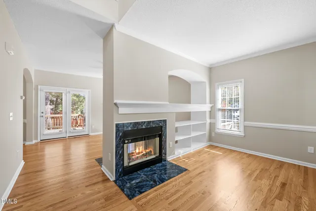 a view of a livingroom with wooden floor and a fireplace