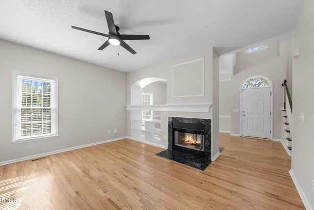 a living room with a fireplace with wooden floor