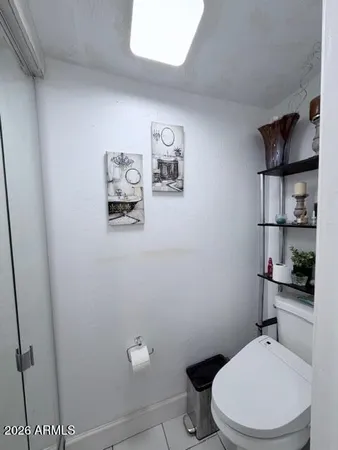 a white toilet sitting next to a bathroom sink and vanity