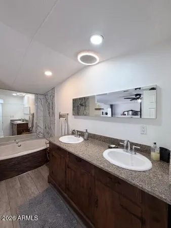 a en suite bathroom with a granite countertop sink and a mirror