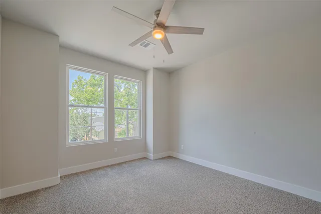 an empty room with closet and a ceiling fan