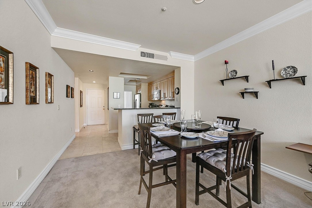 220 East Flamingo Road, Unit 305 Las Vegas, NV 89169 - Photo 2 of 26 Elegant crown molding adorns this spacious dining area seamlessly flowing into a functional kitchen.