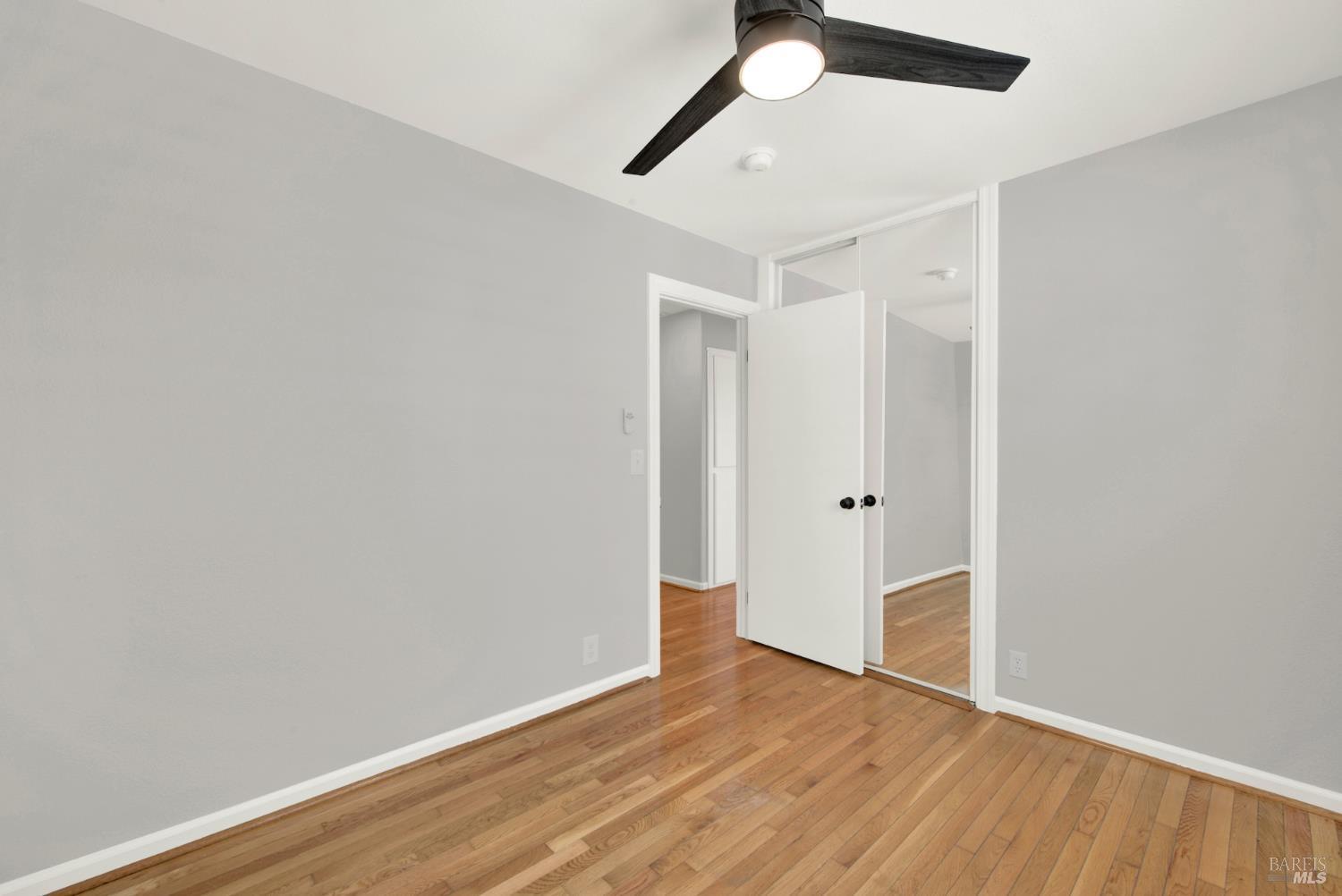 1270 Willow Lake Road Discovery Bay, CA 94505 - Photo 19 of 29 an empty room with wooden floor ceiling fan and window