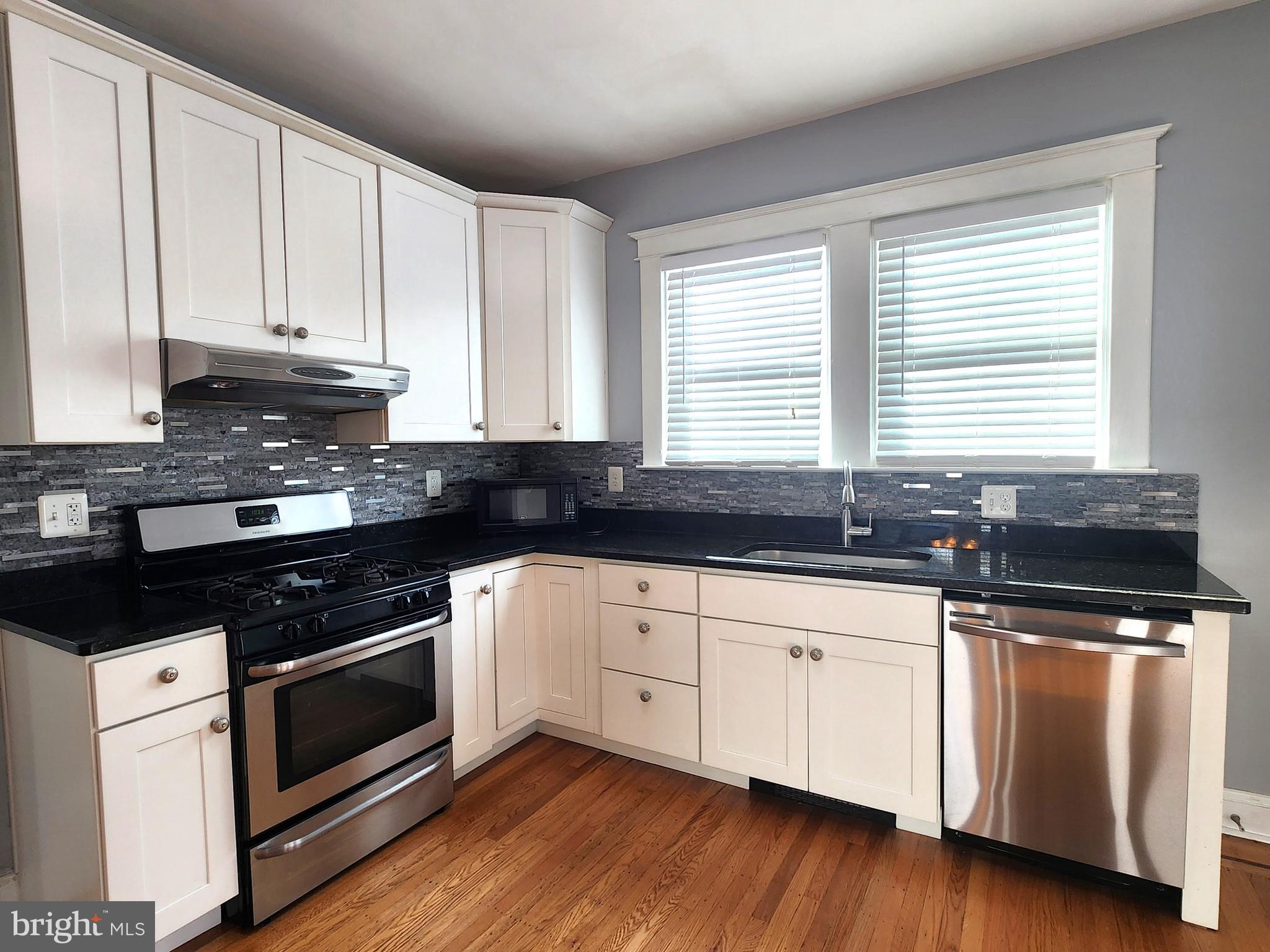 615 Old Home Road Baltimore, MD 21206 - Photo 14 of 31 a kitchen with granite countertop white cabinets and a wooden floor