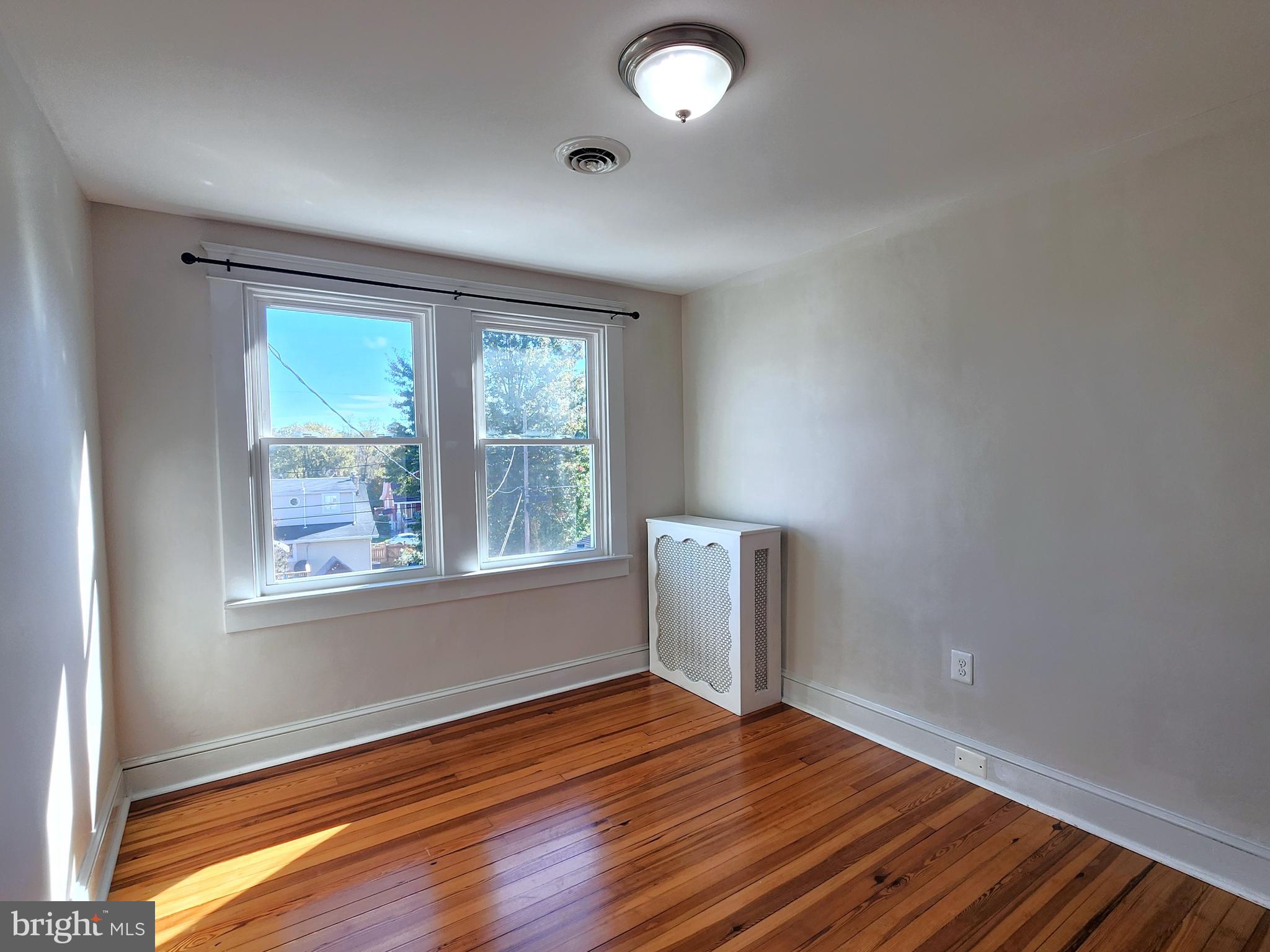 615 Old Home Road Baltimore, MD 21206 - Photo 22 of 31 an empty room with wooden floor and windows