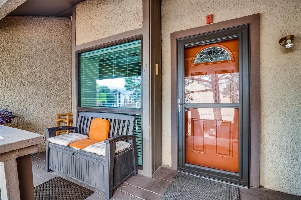 View of exterior entry featuring stucco siding and covered porch