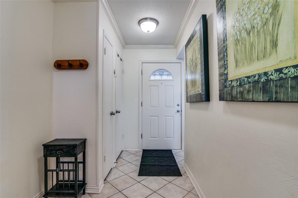 4559 North O'Connor Road, Unit 2289 Irving, TX 75062 - Photo 16 of 23 Doorway to outside featuring crown molding, light tile patterned floors, and baseboards