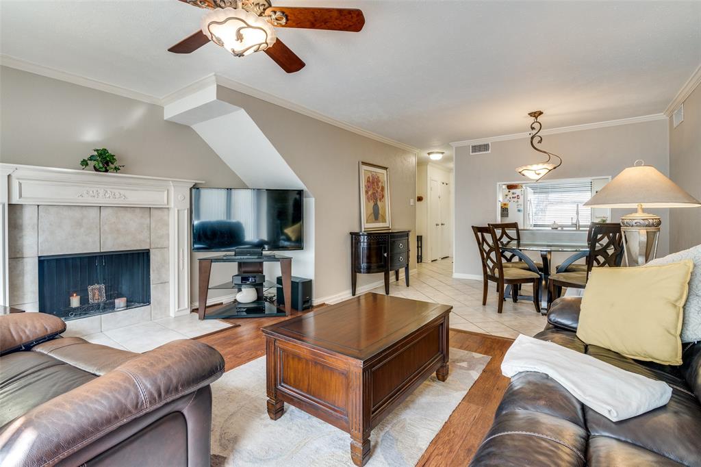 4559 North O'Connor Road, Unit 2289 Irving, TX 75062 - Photo 4 of 23 Living room with ornamental molding, a ceiling fan, light wood-style floors, and a tiled fireplace