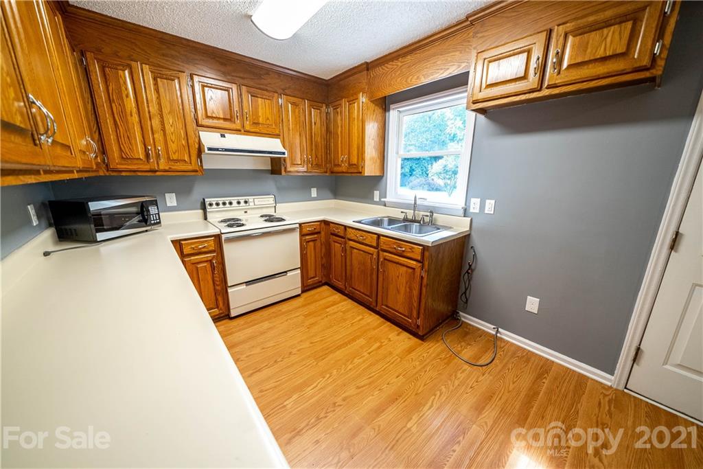 8623 Smith Road Stanfield, NC 28163 - Photo 19 of 27 a kitchen with stainless steel appliances granite countertop a sink a stove and a refrigerator