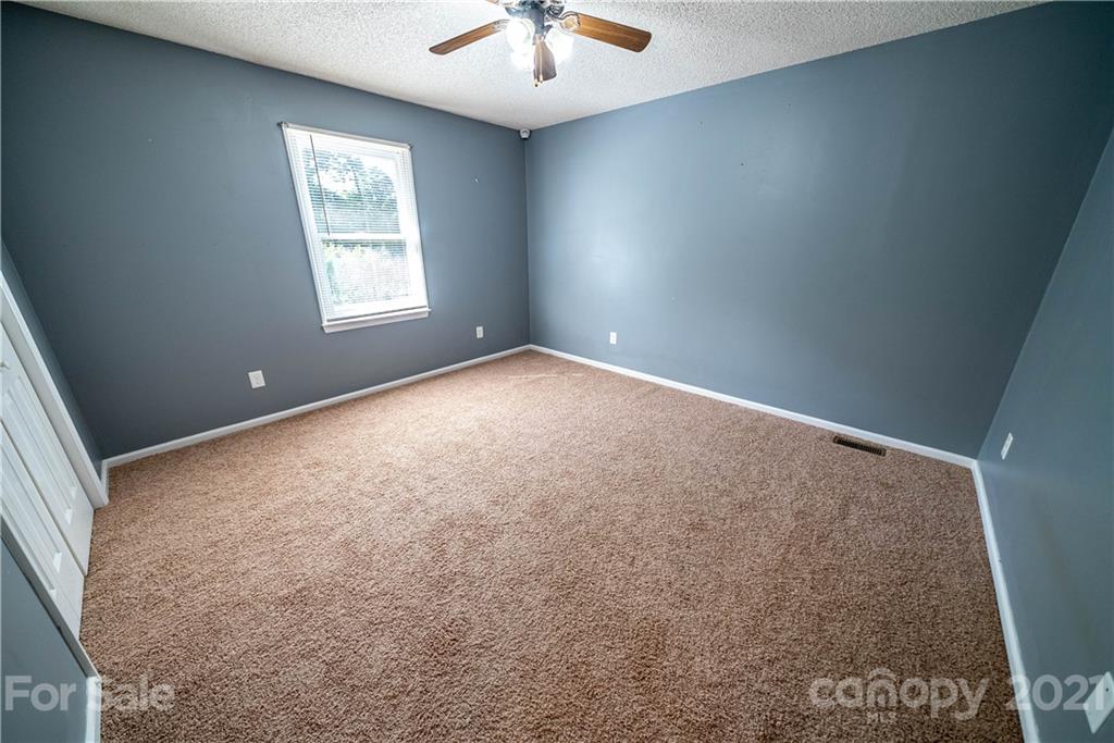 8623 Smith Road Stanfield, NC 28163 - Photo 22 of 27 an empty room with a window and a ceiling fan