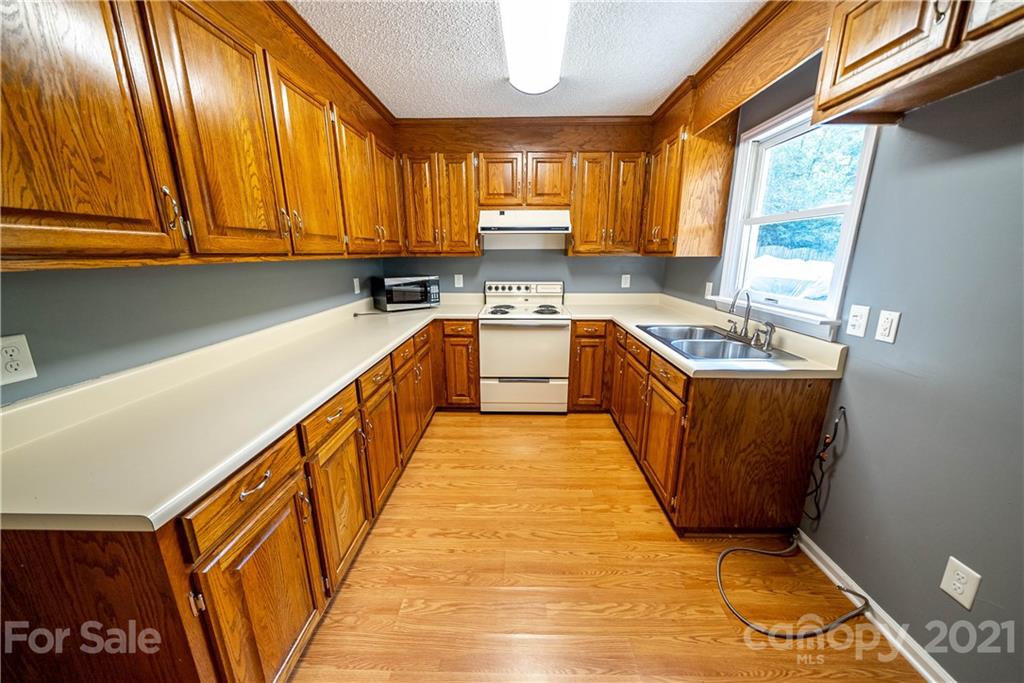 8623 Smith Road Stanfield, NC 28163 - Photo 23 of 27 a kitchen with stainless steel appliances granite countertop a sink a stove and a refrigerator