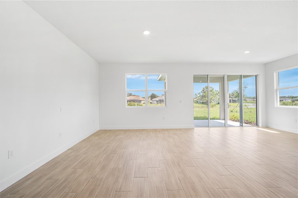9196 Players Drive Weeki Wachee, FL 34613 - Photo 11 of 29 an empty room with wooden floor and windows