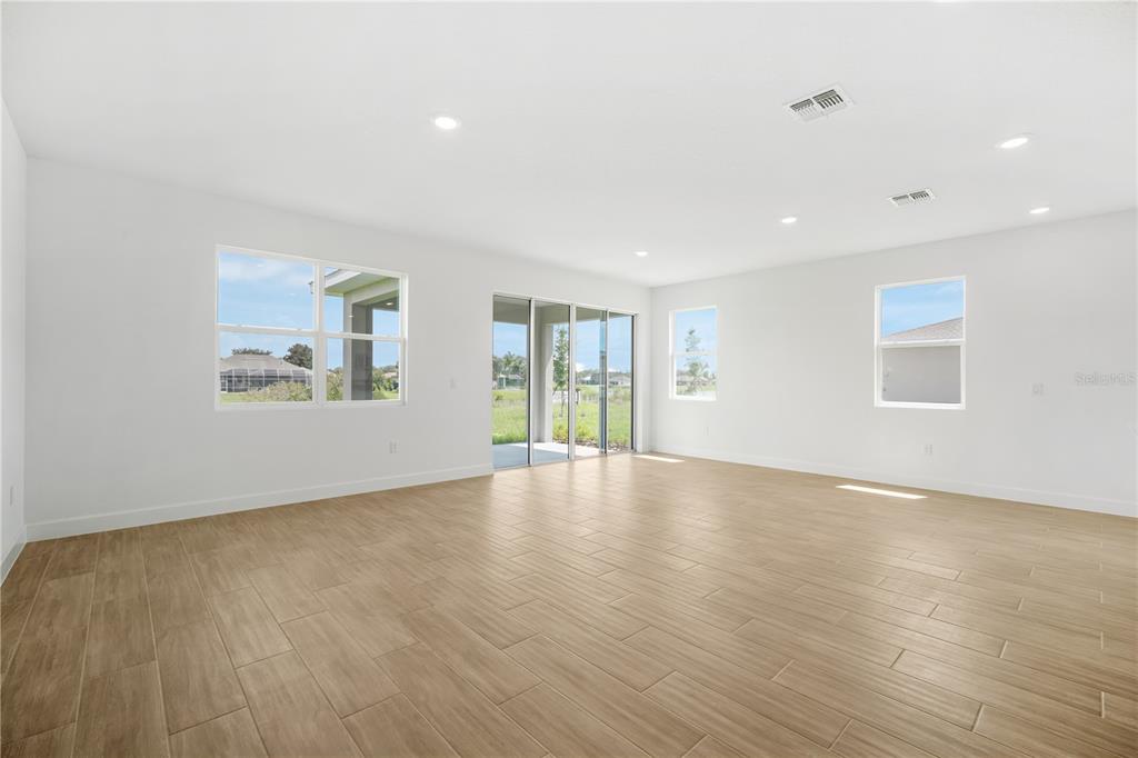 9196 Players Drive Weeki Wachee, FL 34613 - Photo 16 of 29 an empty room with wooden floor and windows