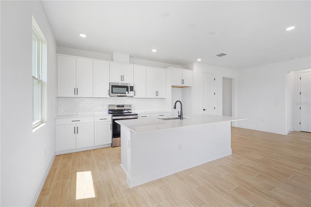 9196 Players Drive Weeki Wachee, FL 34613 - Photo 7 of 29 a view of kitchen with wooden floor sink and refrigerator