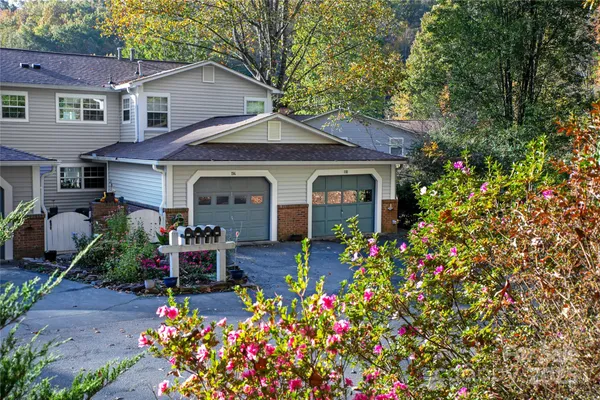 a front view of a house with a porch and garden