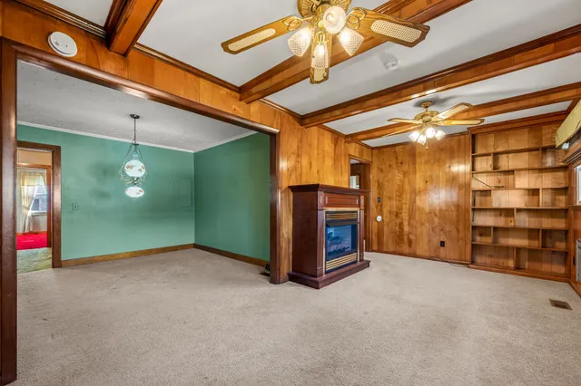 a view of an empty room with a fireplace and a fan