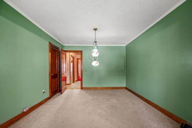 a view of an empty room with window and chandelier fan
