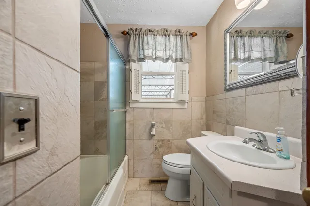 a bathroom with a sink a toilet and a mirror