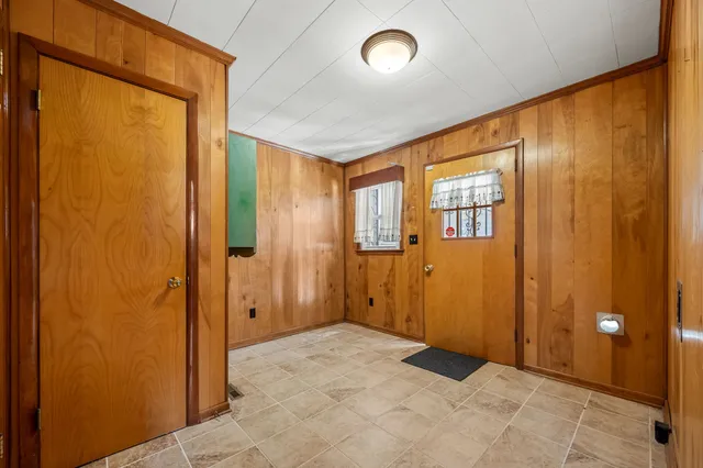 a view of a livingroom with a ceiling fan & hallway