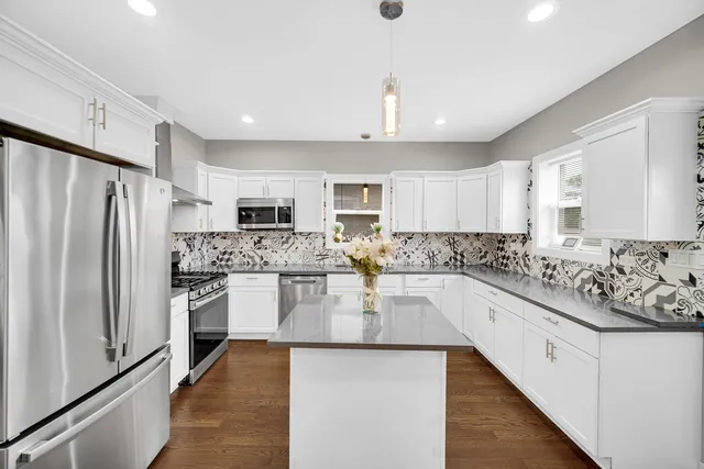 a large kitchen with cabinets stainless steel appliances and a counter top space
