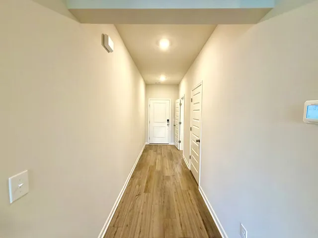 a view of hallway with wooden floor