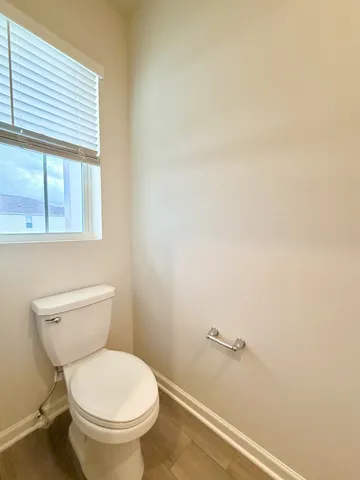 a white toilet sitting next to a window