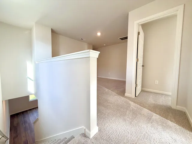 an empty room with closet and a hallway