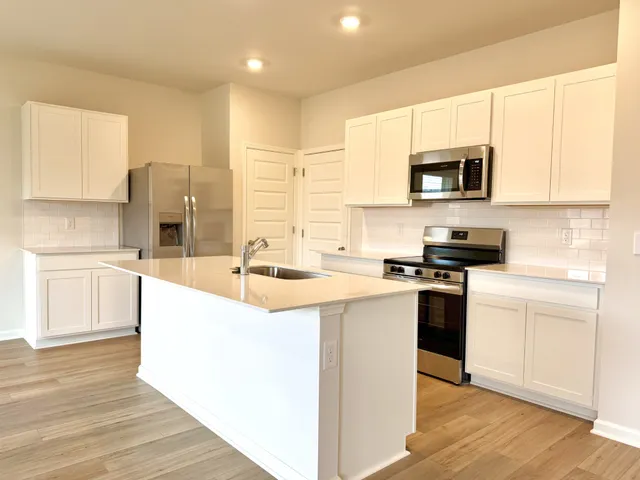 a kitchen with stainless steel appliances granite countertop a sink stove and microwave