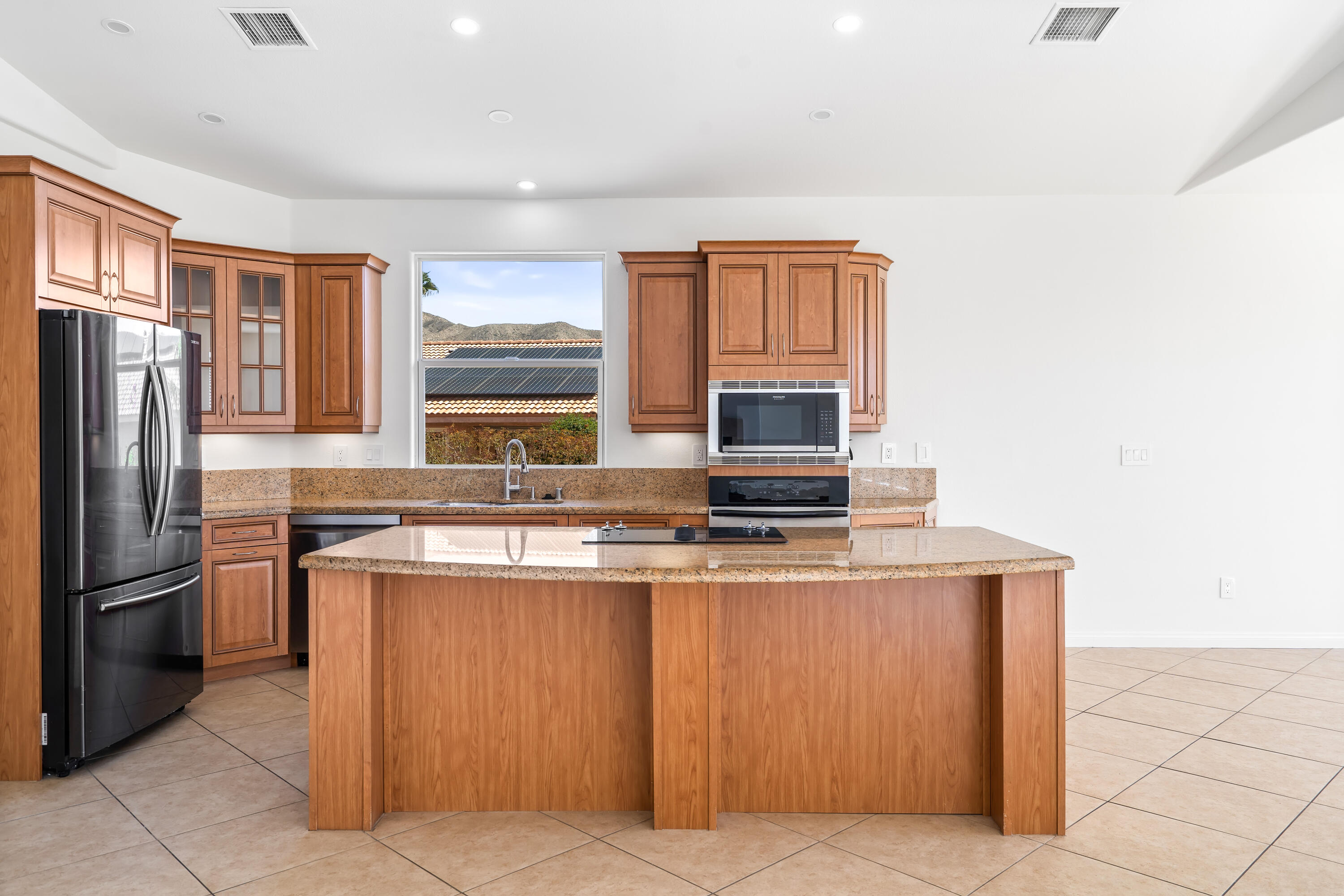9580 Congressional Road Desert Hot Springs, CA 92240 - Photo 4 of 61 a kitchen with stainless steel appliances granite countertop a stove top oven a sink and a refrigerator