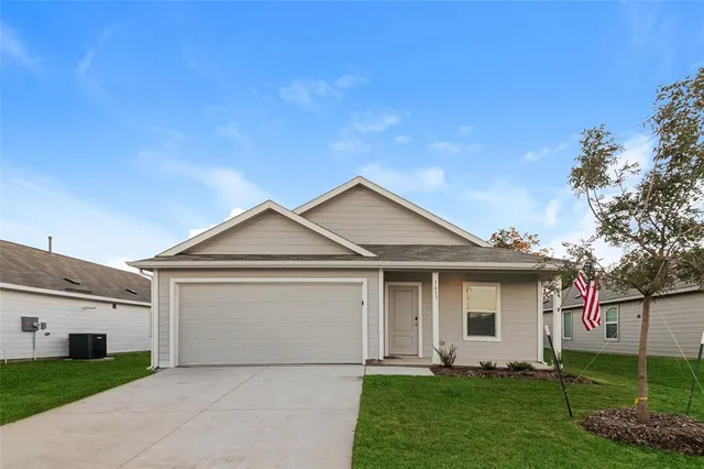 a front view of a house with a garden and yard