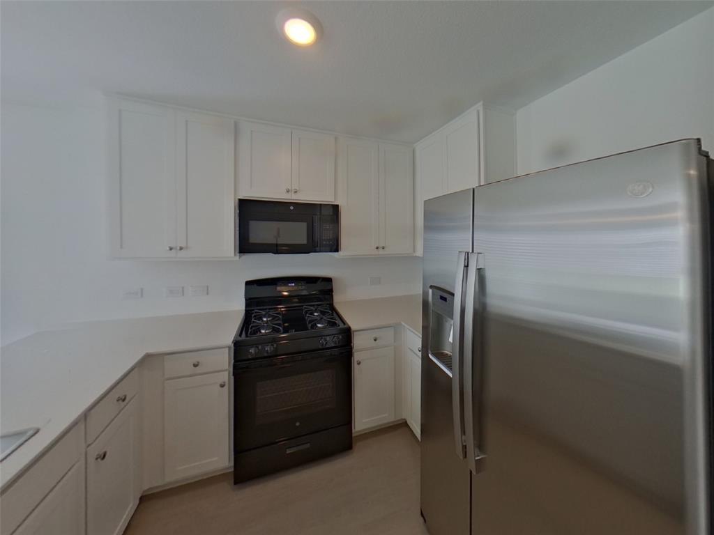 1613 Parlier Street McKinney, TX 75071 - Photo 11 of 22 a kitchen with a refrigerator stove and cabinets