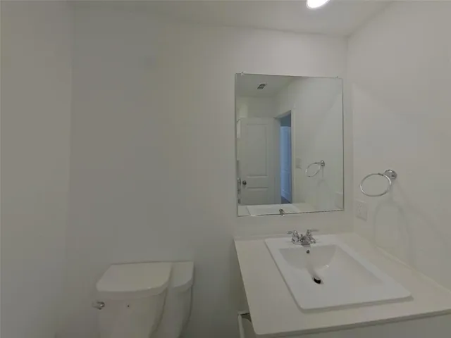 a bathroom with a sink a toilet and mirror