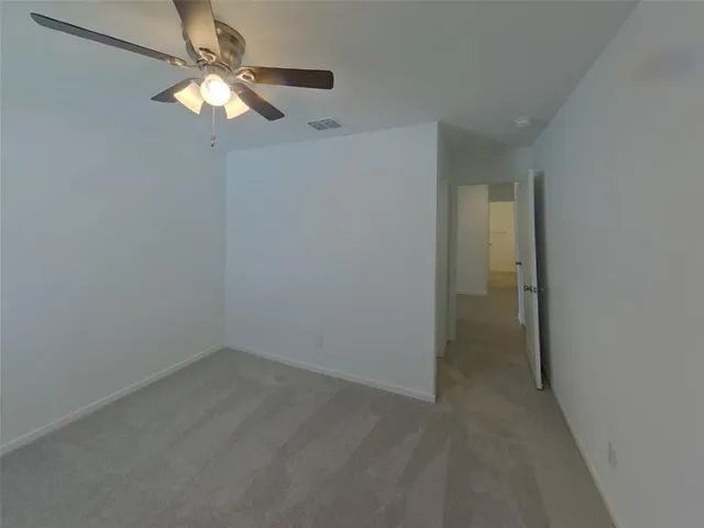 an empty room with a chandelier fan