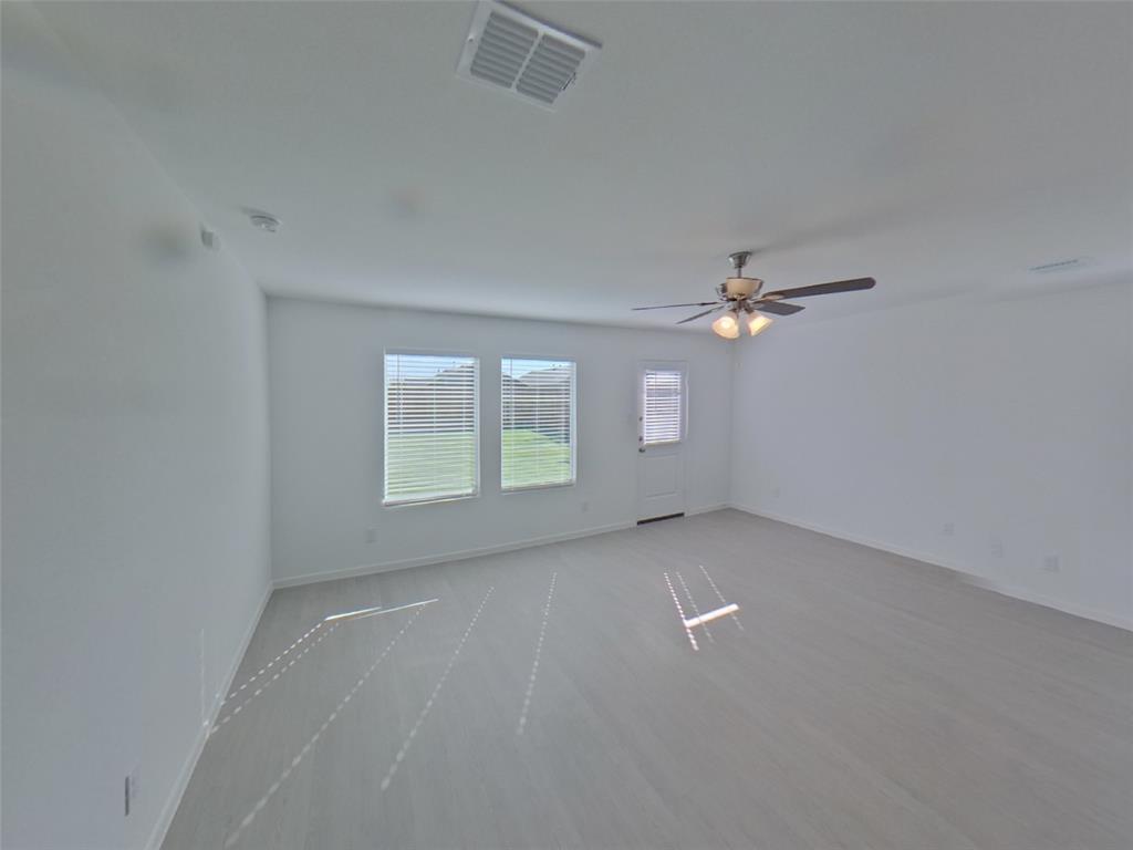 1613 Parlier Street McKinney, TX 75071 - Photo 6 of 22 an empty room with windows and ceiling fan