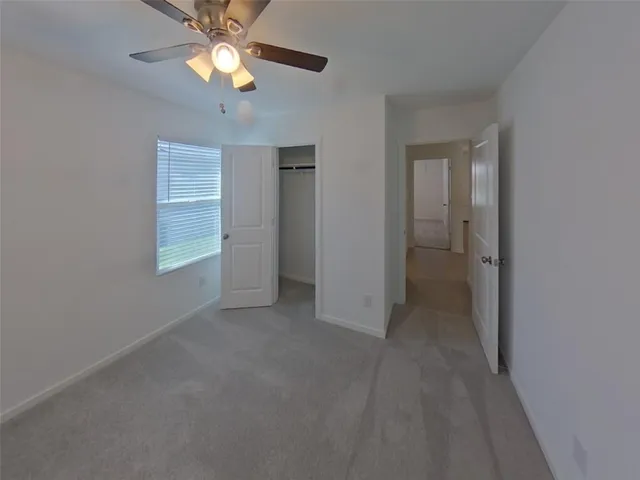 an empty room with closet and a chandelier fan