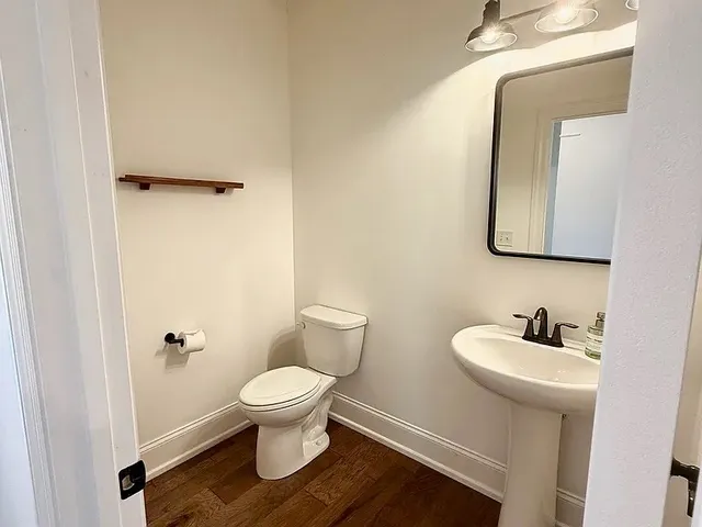 a bathroom with a toilet sink and mirror