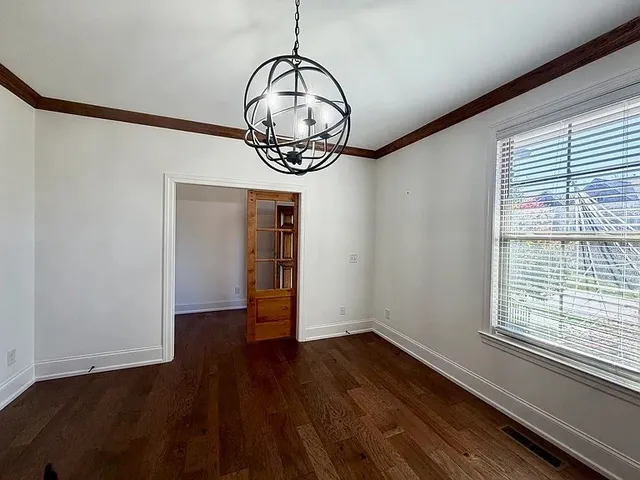 a view of a room with wooden floor water heater and a window