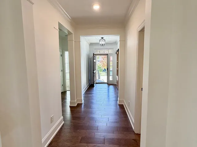 a view of a hallway with wooden floor