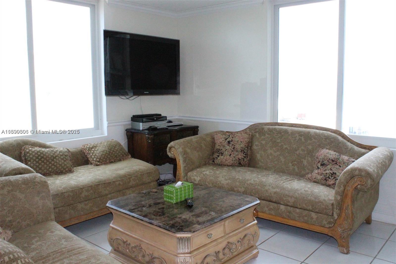 5401 Collins Avenue, Unit 819 Miami Beach, FL 33140 - Photo 22 of 40 a living room with furniture and a flat screen tv