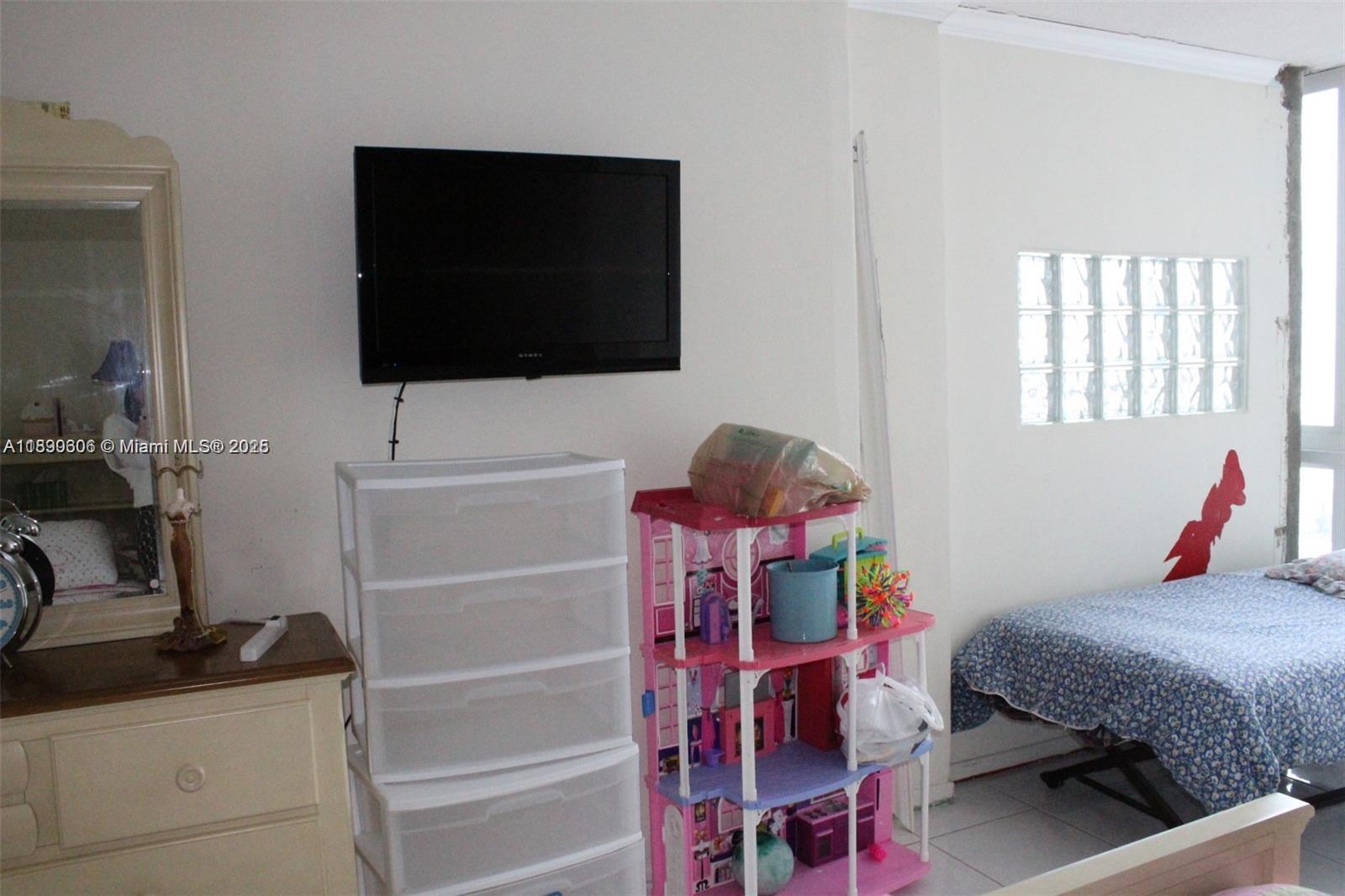 5401 Collins Avenue, Unit 819 Miami Beach, FL 33140 - Photo 31 of 40 a bedroom with a bed and a flat screen tv