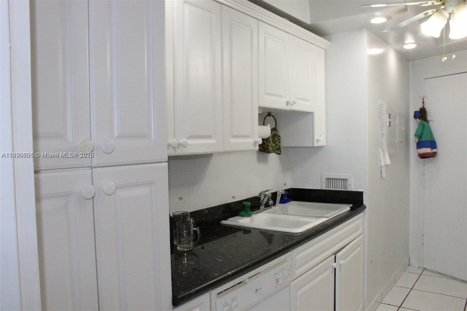 5401 Collins Avenue, Unit 819 Miami Beach, FL 33140 - Photo 36 of 40 a bathroom with a sink and cabinets