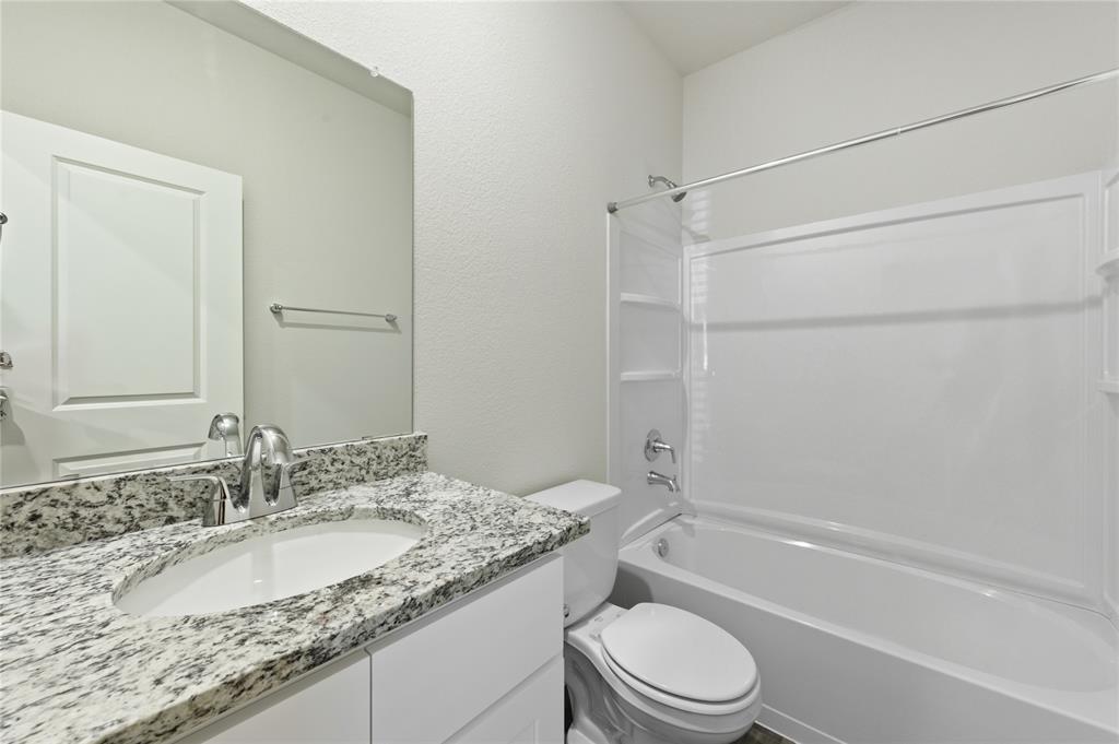 404 Jameson Springtown, TX 76082 - Photo 14 of 16 a bathroom with a granite countertop sink toilet and shower
