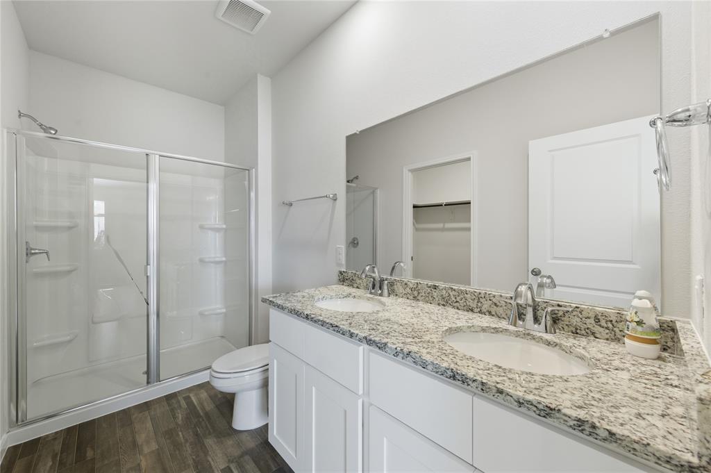 404 Jameson Springtown, TX 76082 - Photo 15 of 16 a bathroom with a granite countertop sink a toilet and shower