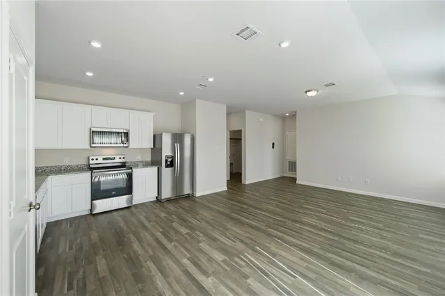 a kitchen with stainless steel appliances a refrigerator and a stove top oven