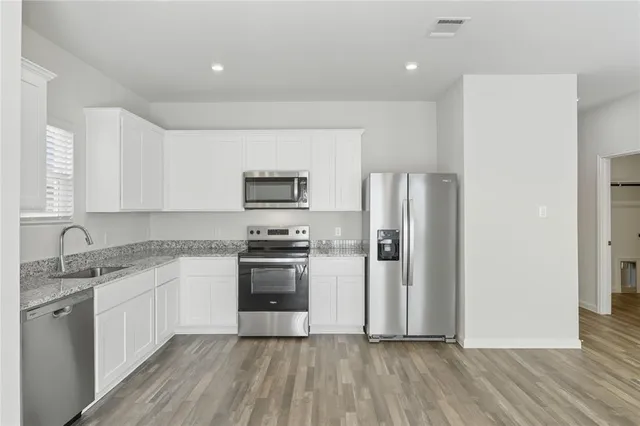 a kitchen with granite countertop a refrigerator and a sink