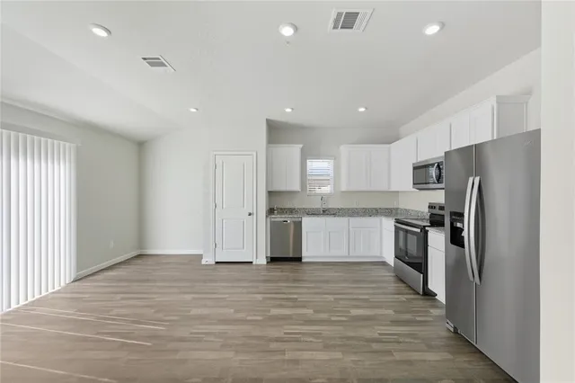 a kitchen with stainless steel appliances a refrigerator sink and microwave