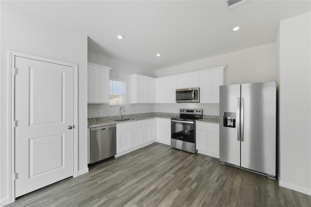 404 Jameson Springtown, TX 76082 - Photo 7 of 16 a kitchen with a refrigerator cabinets and wooden floor