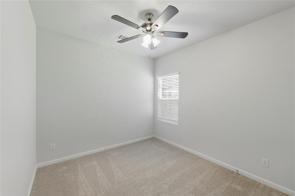 404 Jameson Springtown, TX 76082 - Photo 9 of 16 an empty room with a chandelier fan and windows