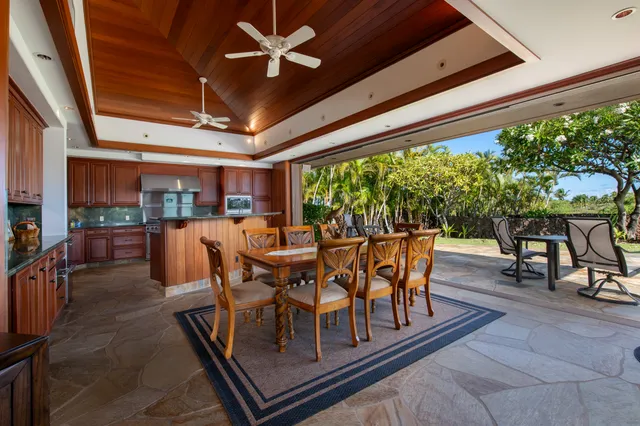 a dining room with furniture a floor to ceiling window and potted plants